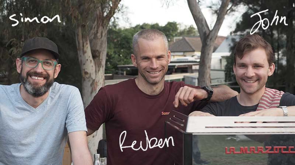 Photo of Simon, Reuben, and John serving coffee under trees in a park near our St Peters roastery